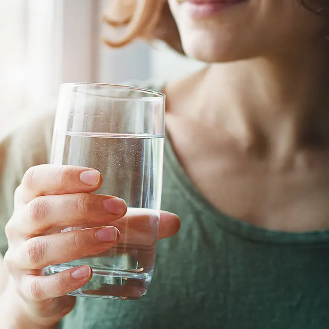 Eine Frau die ein Glas Wasser trinkt