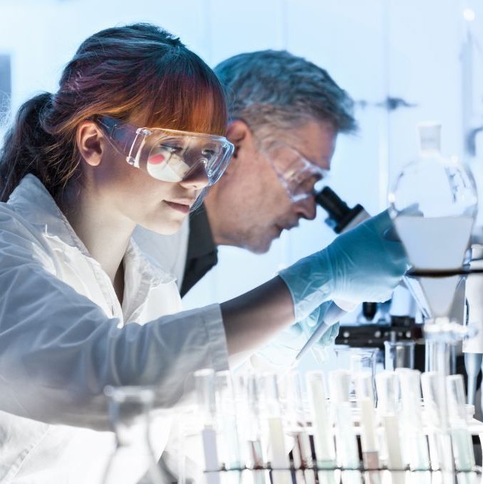 Eine Wissenschaftlerin und ein Wissenschaftler analysieren Proben im Labor mit eienm Mikroskop